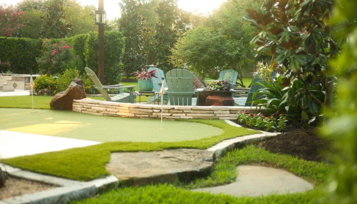 Ultimate backyard for golf and game day featuring a custom synthetic turf putting green, patio seating, and outdoor living space.